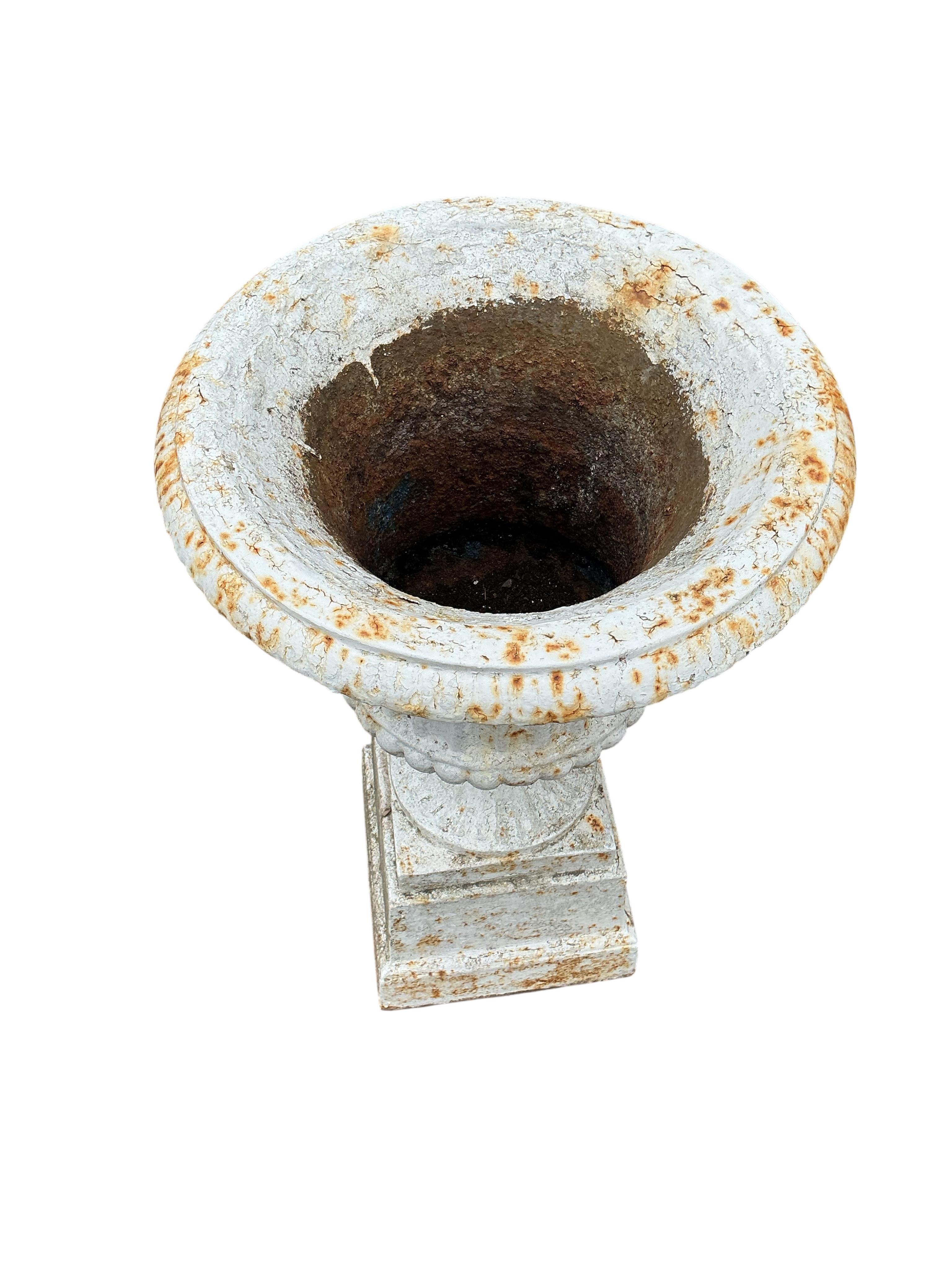 A pair of Victorian cast iron campana garden urns, on square bases, diameter 38cm, height 69cm